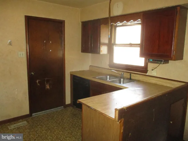 a kitchen with a sink a window and a refrigerator