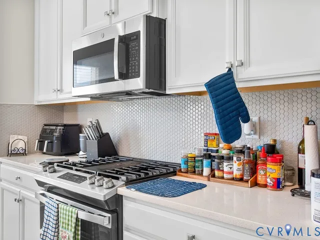 a kitchen with stainless steel appliances granite countertop a stove and a microwave with cabinets