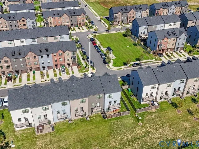 an aerial view of residential houses with outdoor space and parking