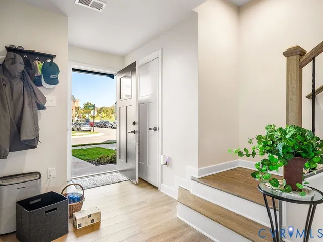 a hallway with a potted plant on the counter and a chair