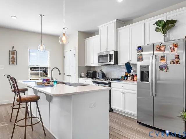 a kitchen with a white cabinets and chairs