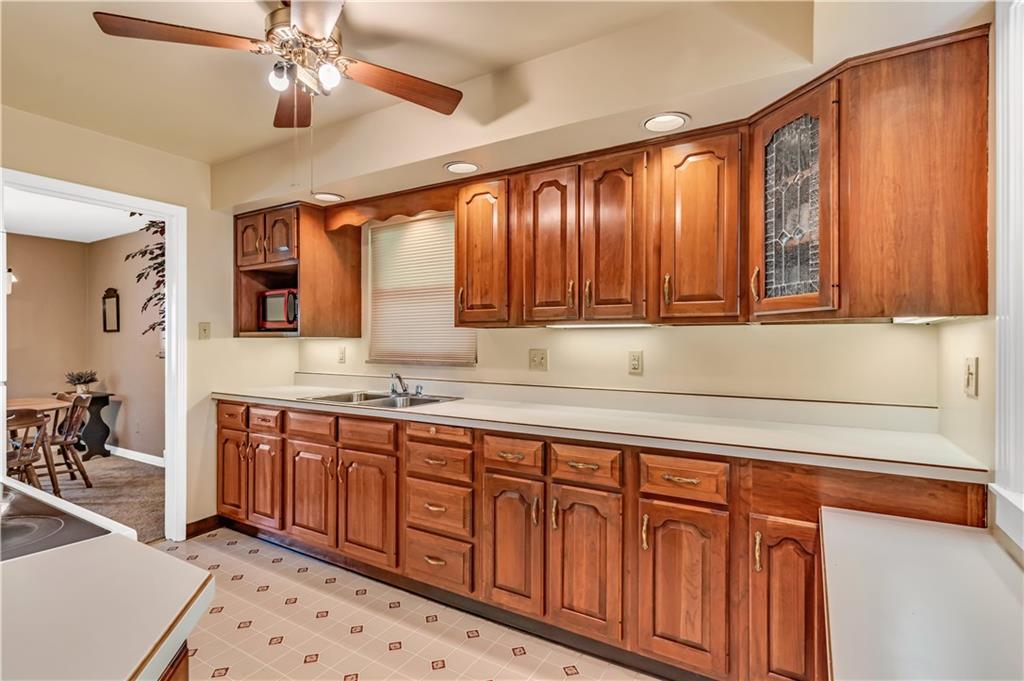 434 Summit Drive Pittsburgh, PA 15228 - Photo 7 of 24 a kitchen with stainless steel appliances granite countertop a sink dishwasher stove and wooden cabinets