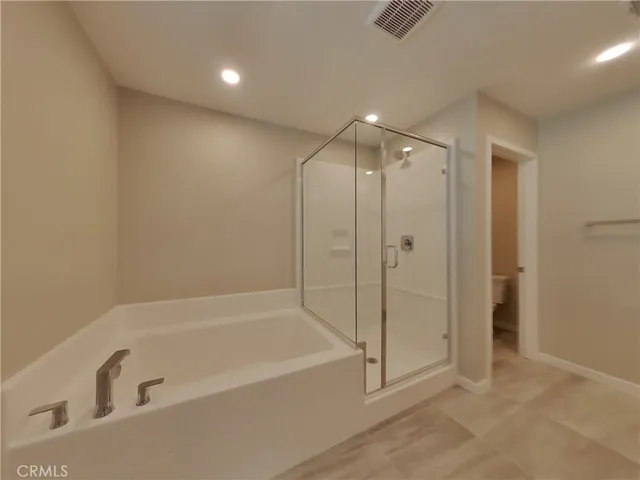 a spacious bathroom with a bathtub and shower
