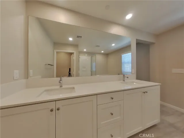 a bathroom with a double vanity sink and a mirror