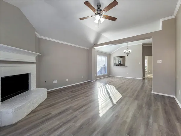 a view of a livingroom with wooden floor and a fireplace
