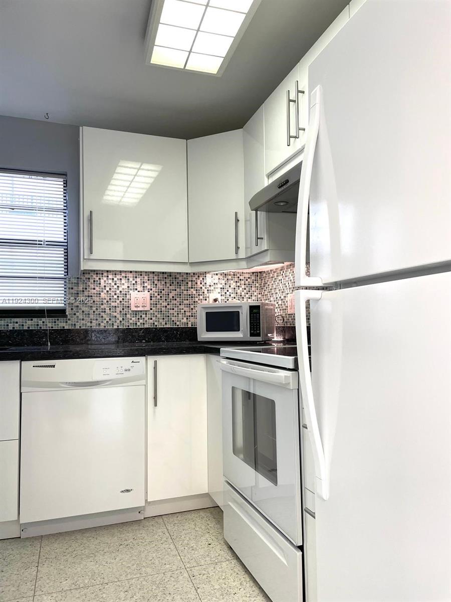 6424 Collins Avenue, Unit 204 Miami Beach, FL 33141 - Photo 9 of 21 a kitchen with stainless steel appliances granite countertop a sink and a refrigerator