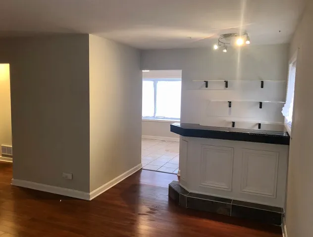a kitchen with granite countertop white cabinets and wooden floor