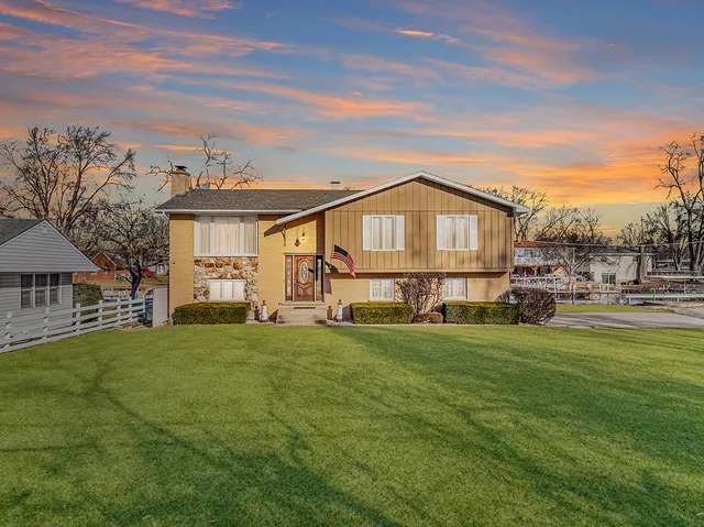 a view of a house with a big yard and large trees