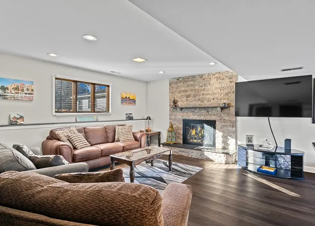 a living room with furniture a flat screen tv and a fireplace
