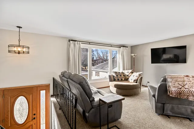 a living room with furniture a flat screen tv and a window