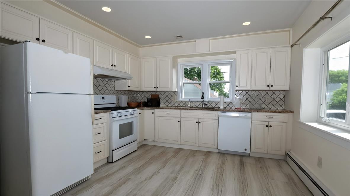172 Harrison Street Emmaus, PA 18049 - Photo 6 of 30 A well-appointed kitchen features white cabinetry and light wood-look flooring.