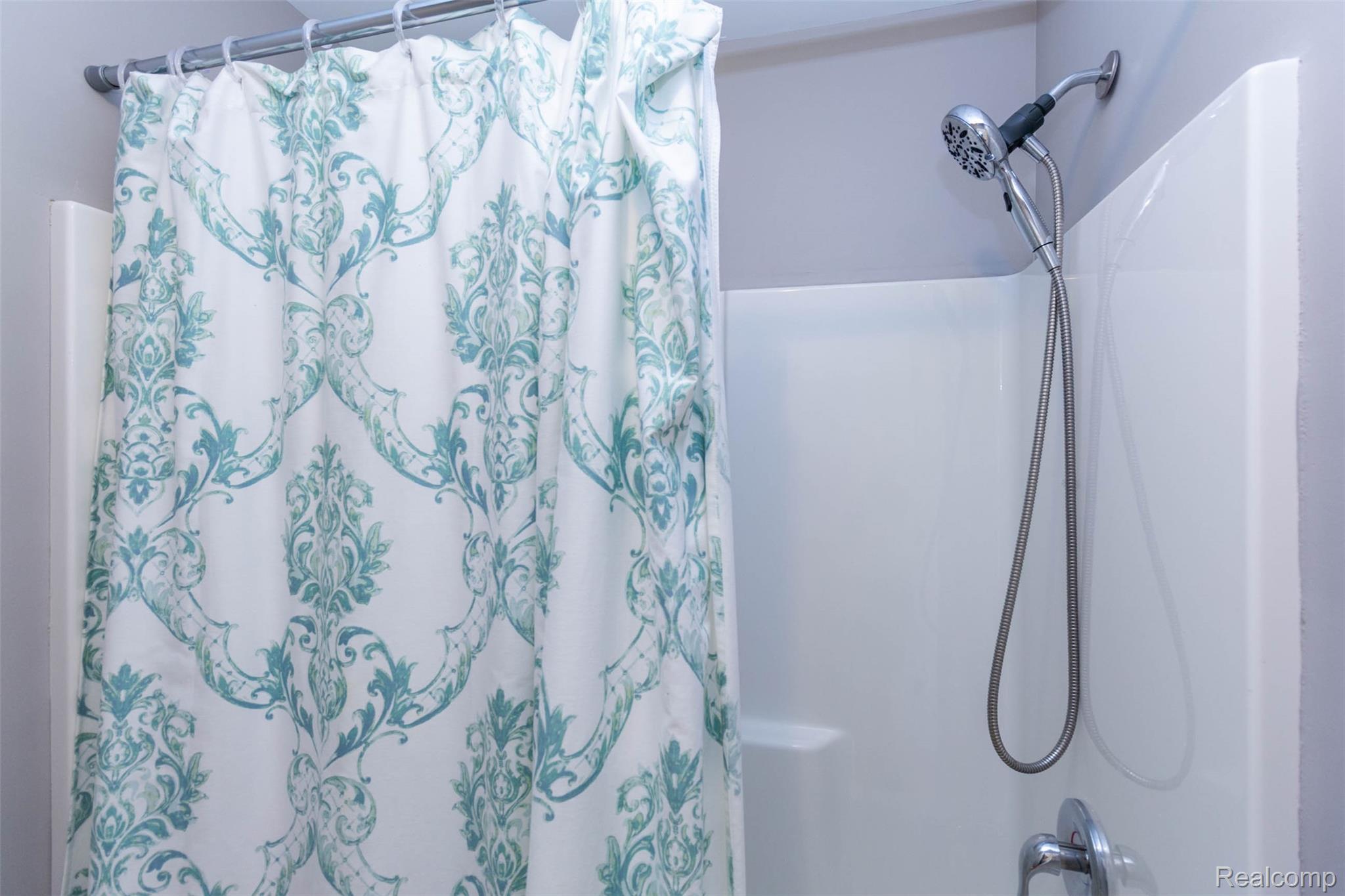 36039 Curtis Road Livonia, MI 48152 - Photo 32 of 61 White shower surround with a chrome handheld shower fixture and a wall-mounted faucet