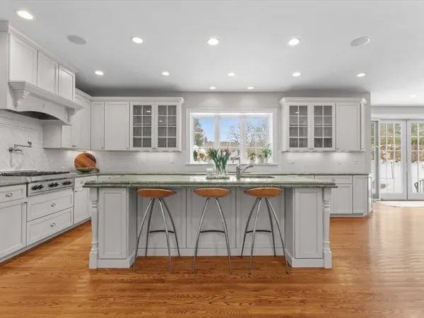 a large kitchen with granite countertop a sink and cabinets
