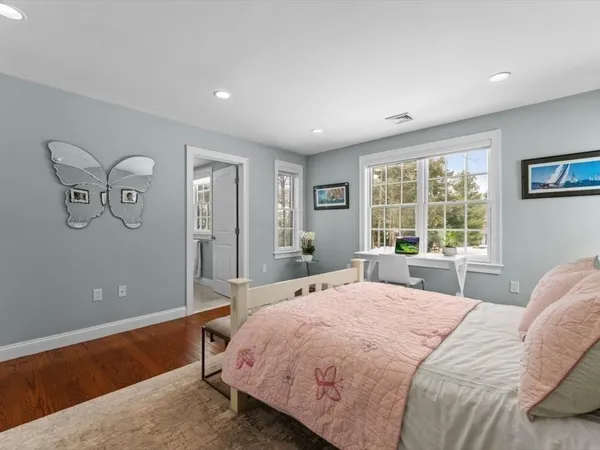 a bedroom with a bed couch and wooden floor
