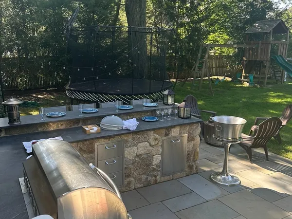 a table and chairs with the view of trees in the background