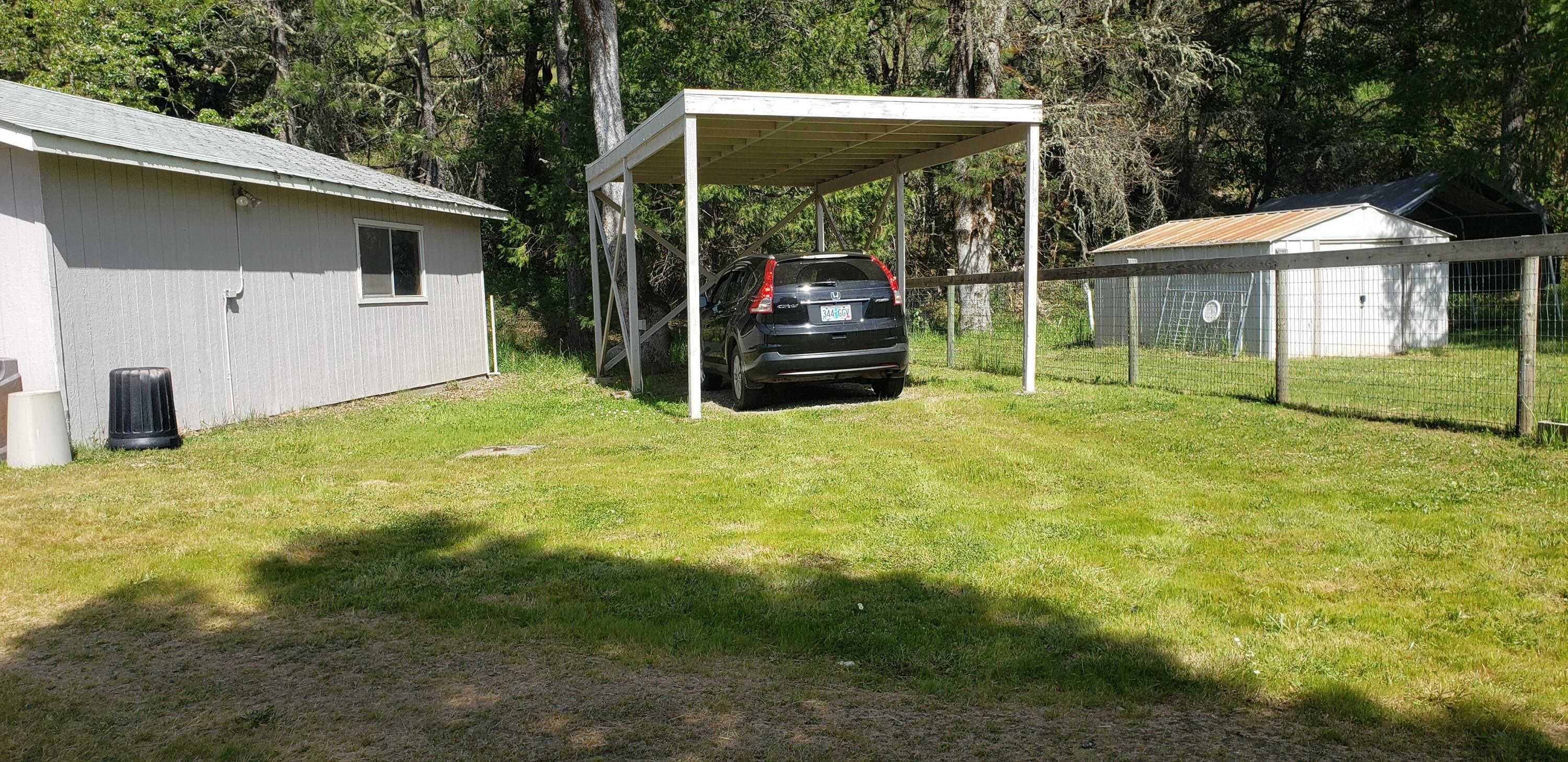 7055 Takilma Road Cave Junction, OR 97523 - Photo 18 of 27 carport, metal shed to right.