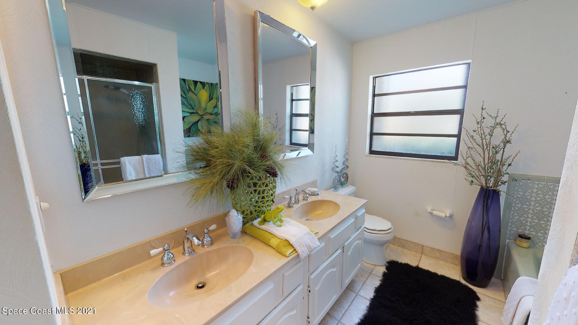 61 Country Club Road Cocoa Beach, FL 32931 - Photo 41 of 100 a bathroom with a sink and a mirror