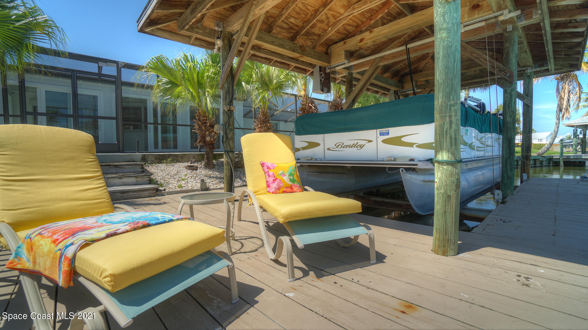61 Country Club Road Cocoa Beach, FL 32931 - Photo 90 of 100 a view of a patio with table and chairs with wooden floor and fence