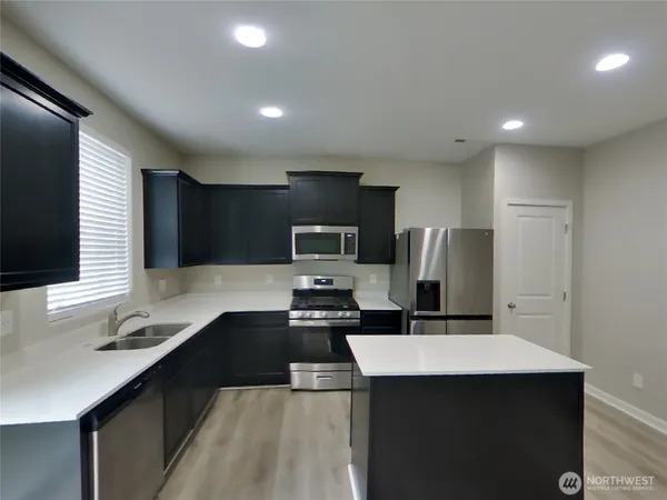 a kitchen with a sink cabinets and stainless steel appliances