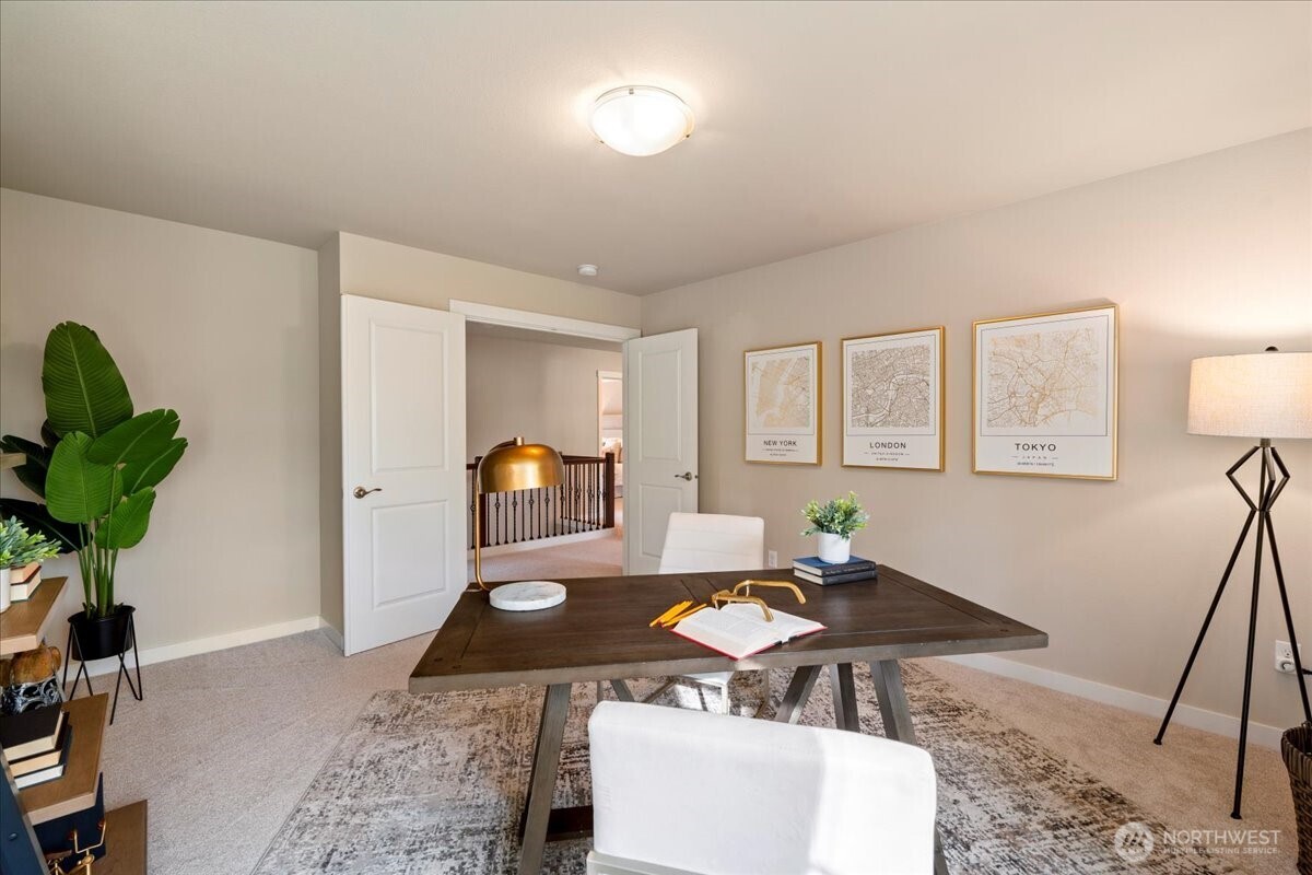 11 200th Place Southwest Bothell, WA 98012 - Photo 33 of 40 a living room with furniture a dining table and paintings on the wall with wooden floor