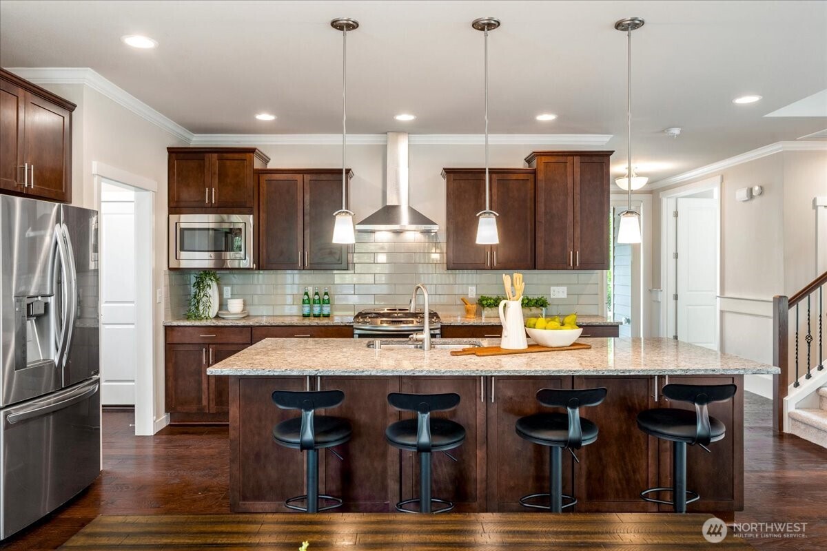 11 200th Place Southwest Bothell, WA 98012 - Photo 8 of 40 a kitchen with stainless steel appliances granite countertop a kitchen island a stove and a refrigerator