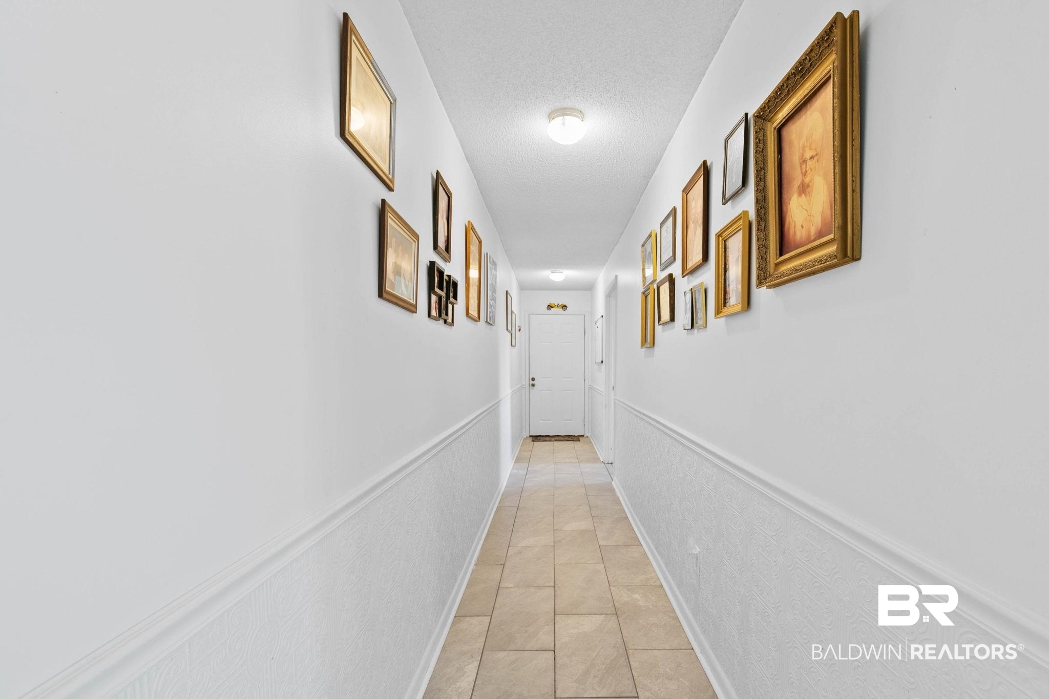 21267 Loop Road Andalusia, AL 36421 - Photo 36 of 72 Hallway featuring wainscoting, light tile patterned floors, and a textured ceiling