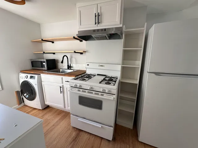 a kitchen with a stove top oven and cabinets