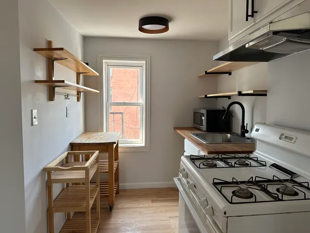 a white stove top oven sitting inside of a kitchen