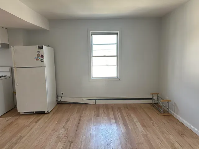 a view of a room with wooden floor and window