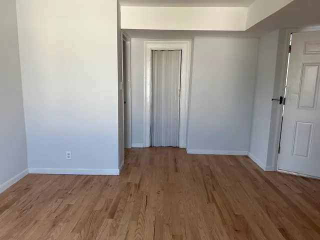 an empty room with wooden floor and closet