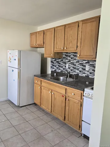 a kitchen with a refrigerator sink and cabinets