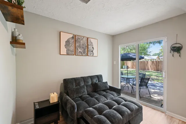a living room with furniture a flat screen tv and a floor to ceiling window