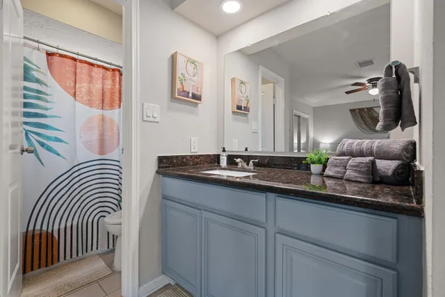a bathroom with a granite countertop sink and a mirror