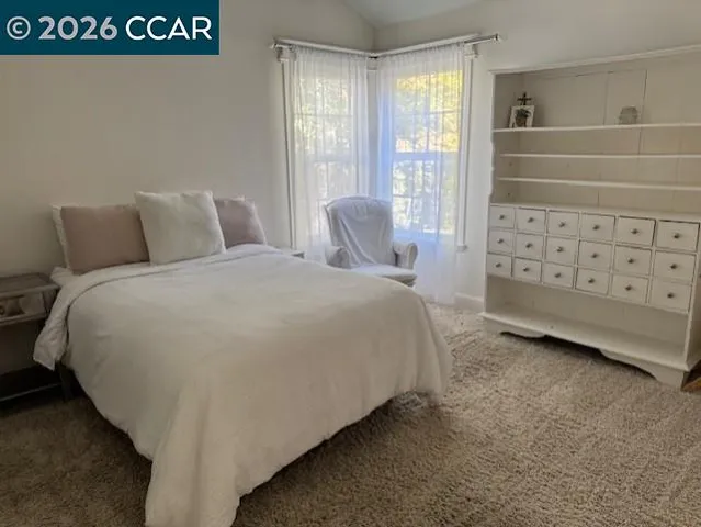 a spacious bedroom with a bed a window and walk in closet