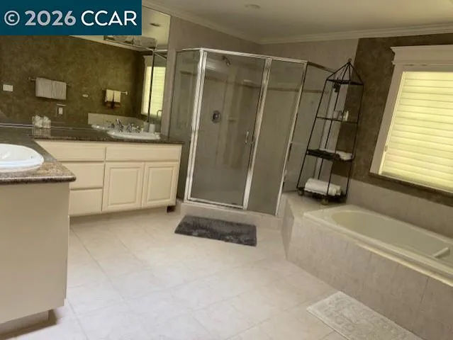 a bathroom with a granite countertop sink a mirror and a bathtub