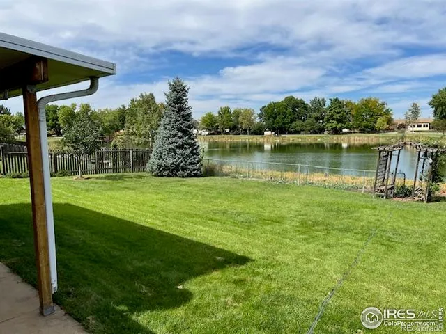 a view of a lake with a big yard and large trees