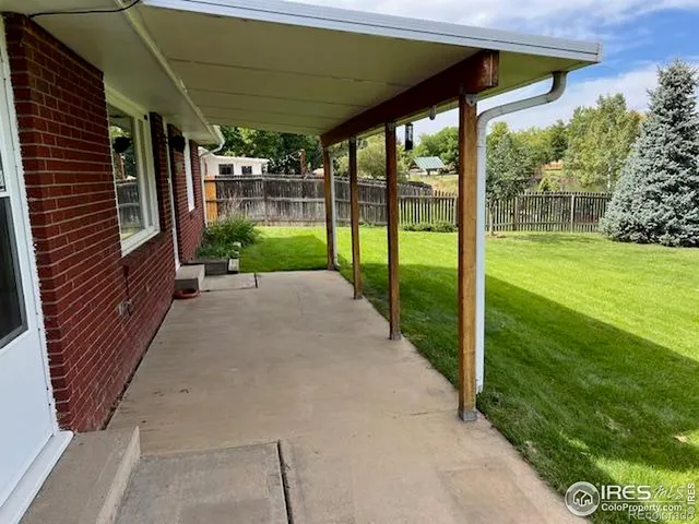 a view of a patio with a table and chairs under a large umbrella