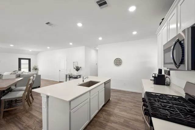 a kitchen with a sink and wooden floor