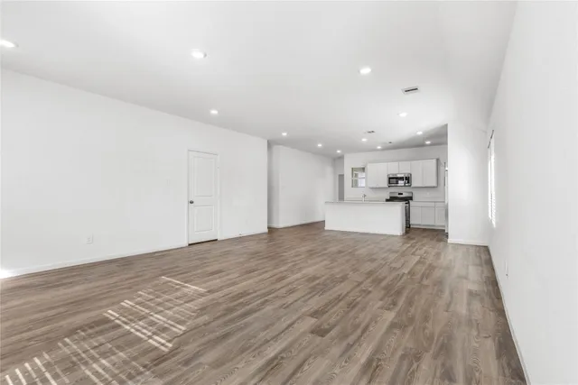 a view of a kitchen with a sink and wooden floor