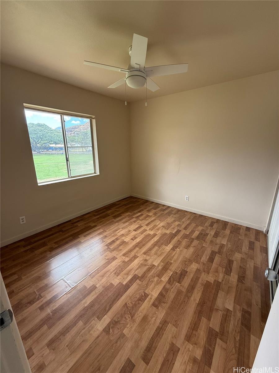 85-808 Lihue Street, Unit UPPR Waianae, HI 96792 - Photo 13 of 19 en empty room with wooden floor and windows