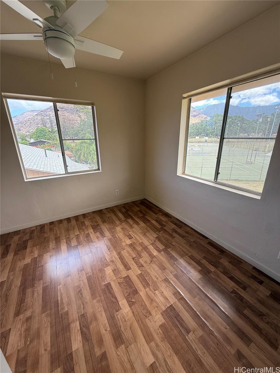 85-808 Lihue Street, Unit UPPR Waianae, HI 96792 - Photo 16 of 19 an empty room with wooden floor fan and windows