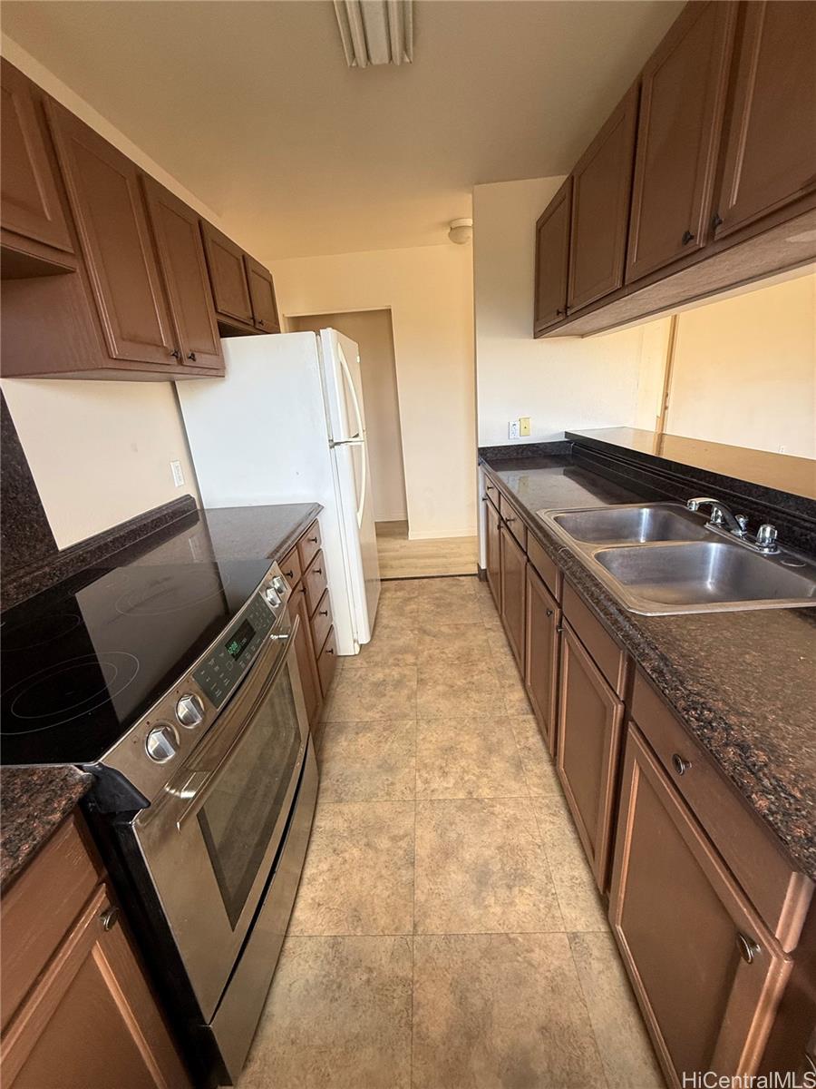 85-808 Lihue Street, Unit UPPR Waianae, HI 96792 - Photo 5 of 19 a kitchen with granite countertop a sink and a stove top oven