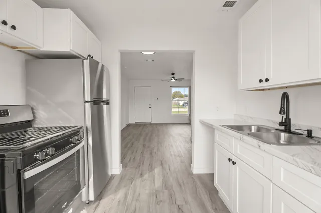 a kitchen with a sink appliances and cabinets