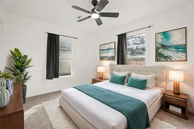 a bedroom with a large bed and a potted plant