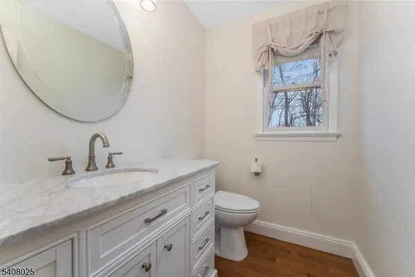 a bathroom with a granite countertop toilet sink and mirror