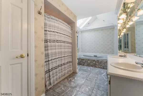 a bathroom with a granite countertop sink a toilet and shower