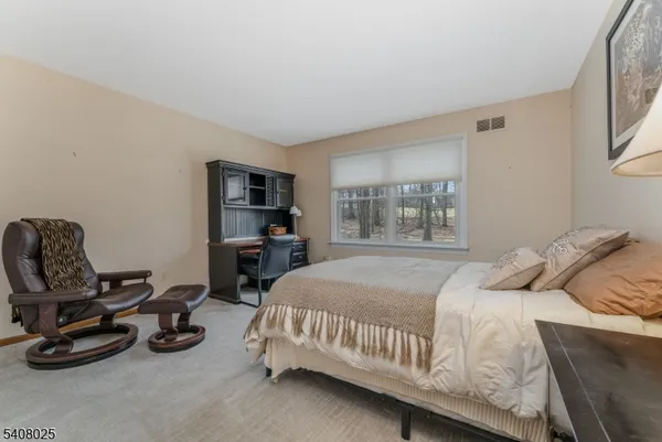 a bedroom with a bed a couch and a window