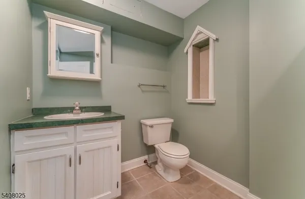 a bathroom with a toilet a sink and mirror