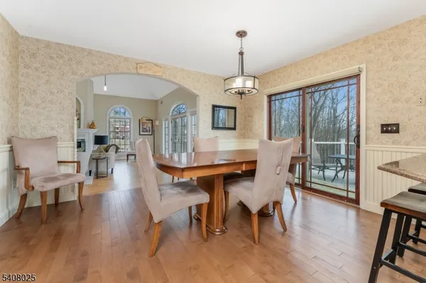 a view of a dining room and livingroom with furniture wooden floor a chandelier