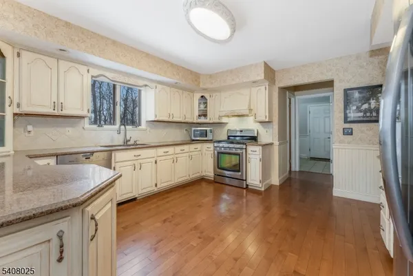 a kitchen with a sink cabinets stainless steel appliances and a window